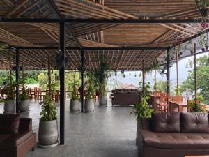 涛岛Echo Hostel Koh Tao的天井配有沙发、桌子和盆栽植物