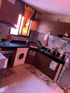 盖尼特拉Tajhiz alliance darna的厨房配有炉灶和洗衣机。