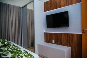 皮廷布Resort Asenza Bangalô Barão 503的卧室配有壁挂式平面电视