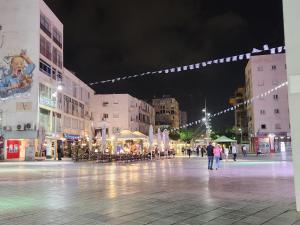内坦亚Chilling in Netanya的夜间的城市广场,人们在周围散步
