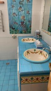 斯伽尔达Bella Vita brīvdienu māja的浴室设有2个水槽和蓝色瓷砖地板。