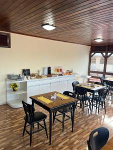 纳塔尔Pousada Recanto de Ponta Negra的带桌椅的房间和厨房