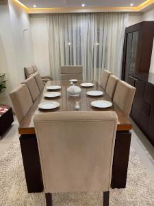 开罗Superb & comfy 3BDR apartment with outstanding view شقة فندقية فاخرة فيو رائع للمطار的客厅配有餐桌和椅子