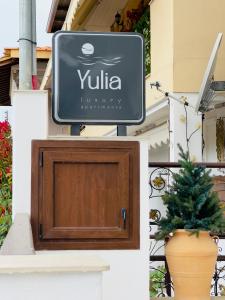 欧拉努波利斯Yulia Luxury Apartment的植物建筑的一侧的标志