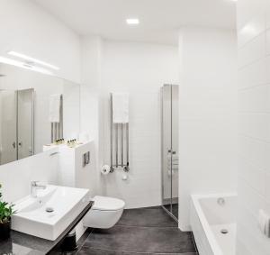 华沙苹果旅馆的白色的浴室设有卫生间和水槽。
