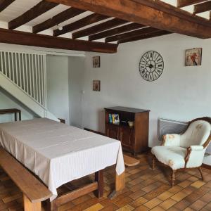 昂比La Balnière Normande的一间卧室配有一张床、一把椅子和闹钟