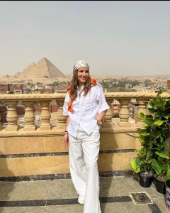 开罗Crowne Pyramids view inn的站在金字塔前的妇女