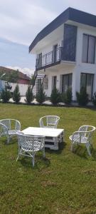 德瓦Accent House的坐在房子前面的草上的一个白长椅