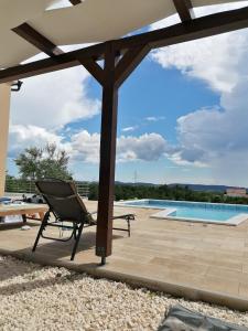 斯克拉丁Villa Scolopax rusticola Skradin with heated pool的一个带椅子的庭院和一个游泳池