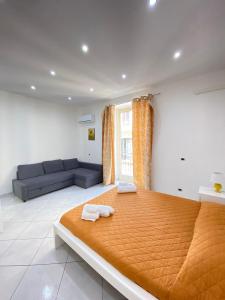 巴勒莫Marechiaro Apartments的一间卧室配有一张大床和一张沙发