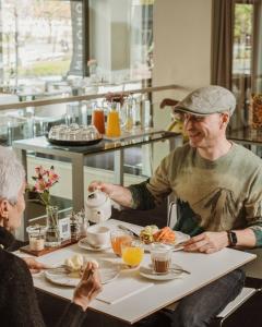 毕尔巴鄂米罗酒店的两个老人坐在桌子上吃食物