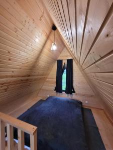 卡兹贝吉Pine Chalet Kazbegi的木制客房的一张床位,设有窗户
