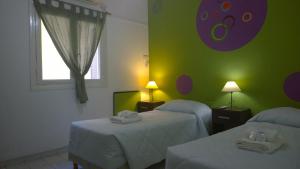 布宜诺斯艾利斯克滕酒店的一间设有两张床和绿色墙壁的客房