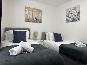 Great OakleySuperb 2 bedroomed apartment的一间卧室配有两张带毛巾的床