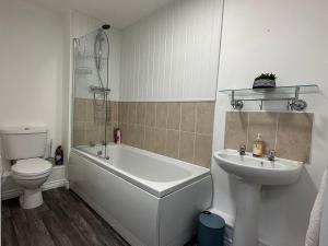 Great OakleySuperb 2 bedroomed apartment的带浴缸、盥洗盆和卫生间的浴室
