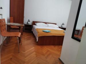 尼亚卢卡Marina的一间卧室配有一张床、一张桌子和一张桌子