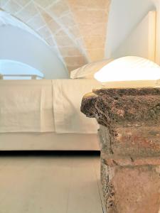 加利波利LE DIMORE CENTRO的一间卧室配有一张床和一张带台灯的桌子