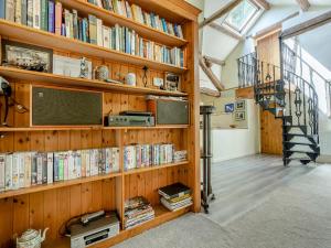 Askham磨坊谷仓度假屋的书架上书架,书架上摆放着楼梯旁的书籍