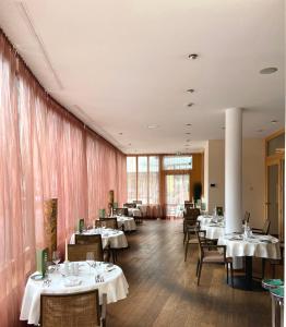 胡普加顿蒂弗雷雪松音水疗酒店的用餐室配有桌椅和粉红色窗帘