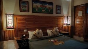 麦罗肯机Auspiscious Him View Hotel的一间卧室配有一张带木制床头板的床