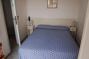 维亚雷焦翁蒂娜酒店的一间卧室配有一张带蓝色和白色棉被的床