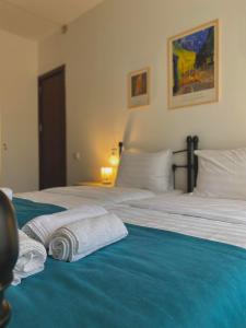 卡兹贝吉Mood Hotel Kazbegi的一间卧室配有一张床,上面有两条毛巾