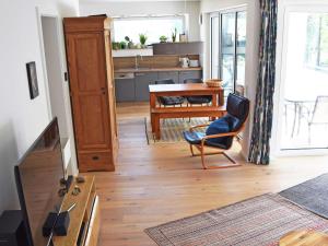 奥斯赛拜-塞林Haus "Jasmund" F 646 WG 02 mit Kamin, Sauna, Whirlwanne, Terrasse的厨房以及带桌椅的起居室。
