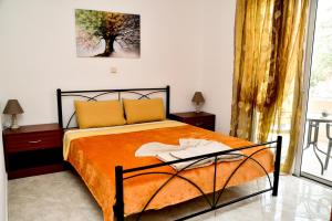 阿彻奇洛斯ADONIOS APARTMENTS的一间卧室配有一张带橙色毯子的床