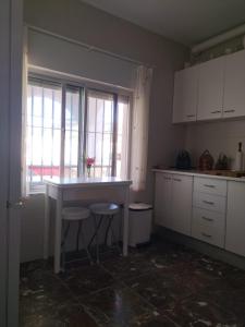奇皮奥纳Villa Antonia的厨房配有桌子、两张凳子和窗户