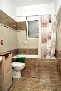 阿彻奇洛斯ADONIOS APARTMENTS的一间带卫生间和浴缸的浴室以及窗户。
