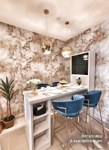 哥打京那巴鲁Seaview Luxury Suites at The Shore Kota Kinabalu的一间配备有白色桌子和蓝色椅子的用餐室