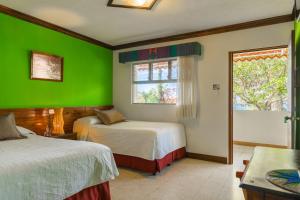帕纳哈切尔河流花园会议中心酒店的绿色的客房设有两张床和窗户。