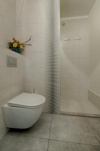 绿山城Apartamenty MM - Chmielna的白色的浴室设有卫生间和淋浴。