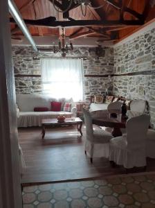 桑加拉达Ξυλοπετρα / Wood & stone house的客厅配有桌椅和沙发