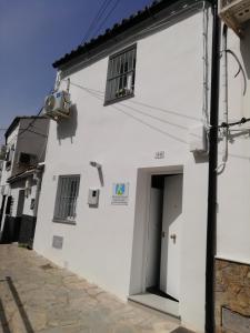 乌夫里克La Casita de Ubrique的白色的建筑,有门和窗户