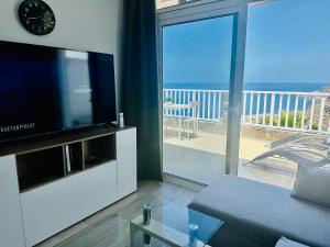 阿马多雷斯AMADORES BALCONY - WITH OCEAN VIEW.的带沙发和电视的客厅以及阳台。