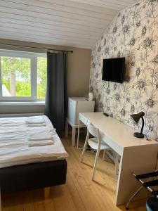 萨翁林纳Norppa Resort的一间卧室配有一张床、一张书桌和一台电视。
