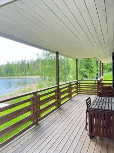 萨翁林纳Norppa Resort的湖景木制甲板,配有长凳