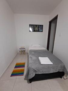 波哥大Makarena Hostel的一间卧室配有床和色彩缤纷的地毯。