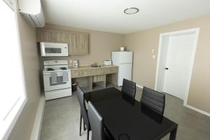 BeresfordMotel 7 Inn & Suites的厨房配有黑桌和白色冰箱。