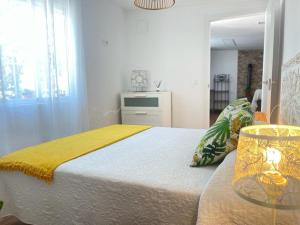 Los Santos de MaimonaFinca el atardecer- Apartamento El Peral的一间卧室配有一张黄色毯子床