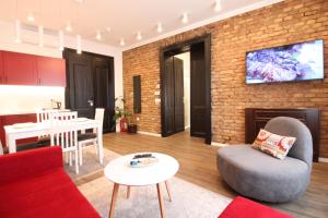 萨拉热窝Sarajevo History Apartments的客厅设有红色沙发和砖墙