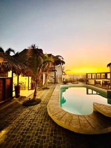 洛斯拉甘斯老港酒店的拥有游泳池和棕榈树的度假村,享有日落美景
