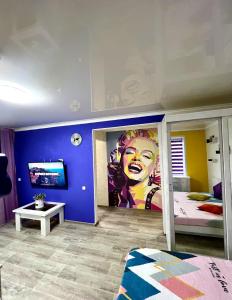 卡拉甘达Яркая квартира в стиле Поп Арт в центре города Караганда的墙上有女人壁画的卧室