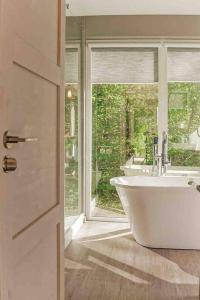 斯伽尔达Fridis&Chill的一间带白色浴缸和窗户的浴室