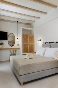圣安娜纳克索斯Aesthete Suites的白色卧室设有一张大床和镜子