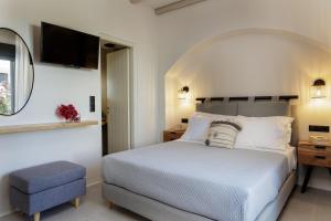 圣安娜纳克索斯Aesthete Suites的卧室配有白色的床和镜子