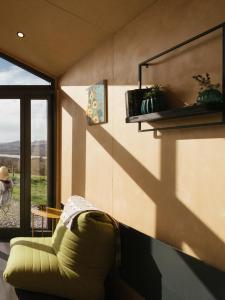 肯梅尔Oaklane Glamping Cabins的客厅设有绿色沙发和窗户。