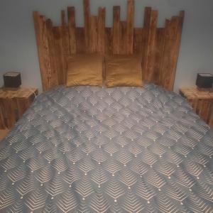 唐莱沃斯热F2 Mass & Bo的卧室内的一张床位,配有木制床头板