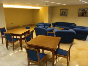 比拉尔瓦维拉多阿尔巴酒店的一间设有桌子和蓝色椅子的等候室